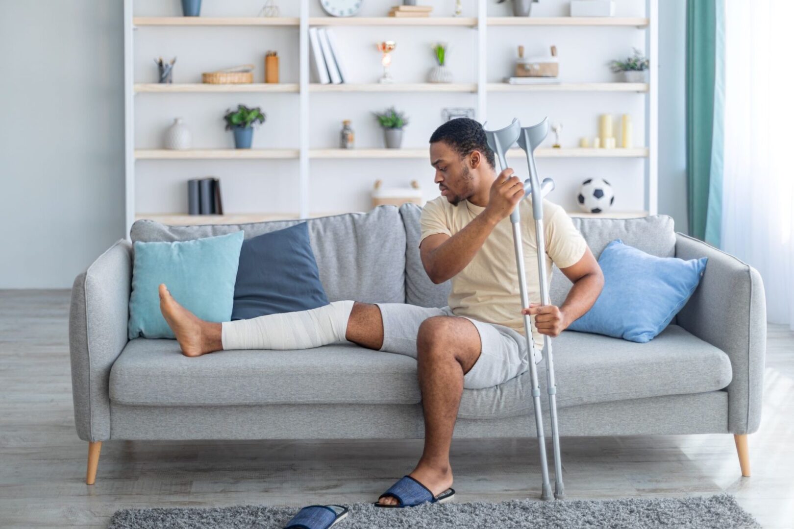 A man with his leg in plaster on the couch