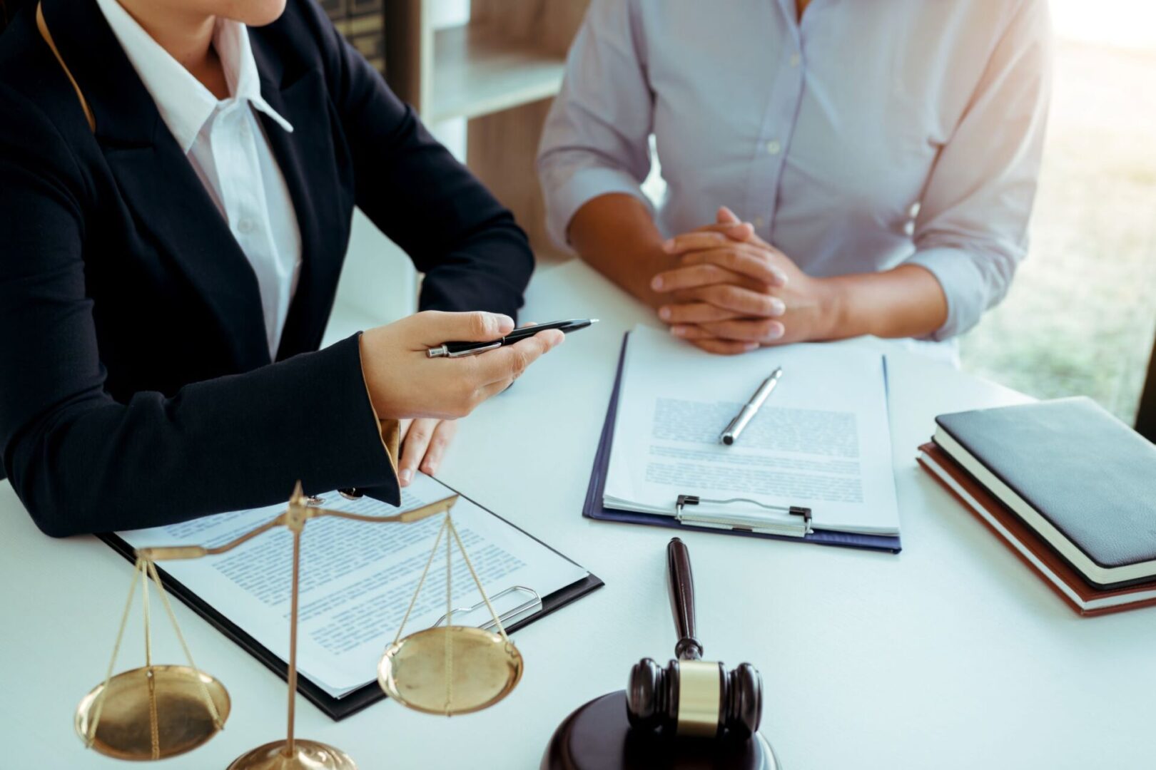 A couple of people sitting at a table with papers.